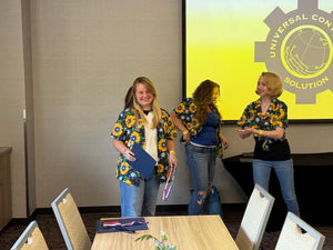 Universal Controls Solution employees in custom sunflower Hawaiian shirts at awards ceremony